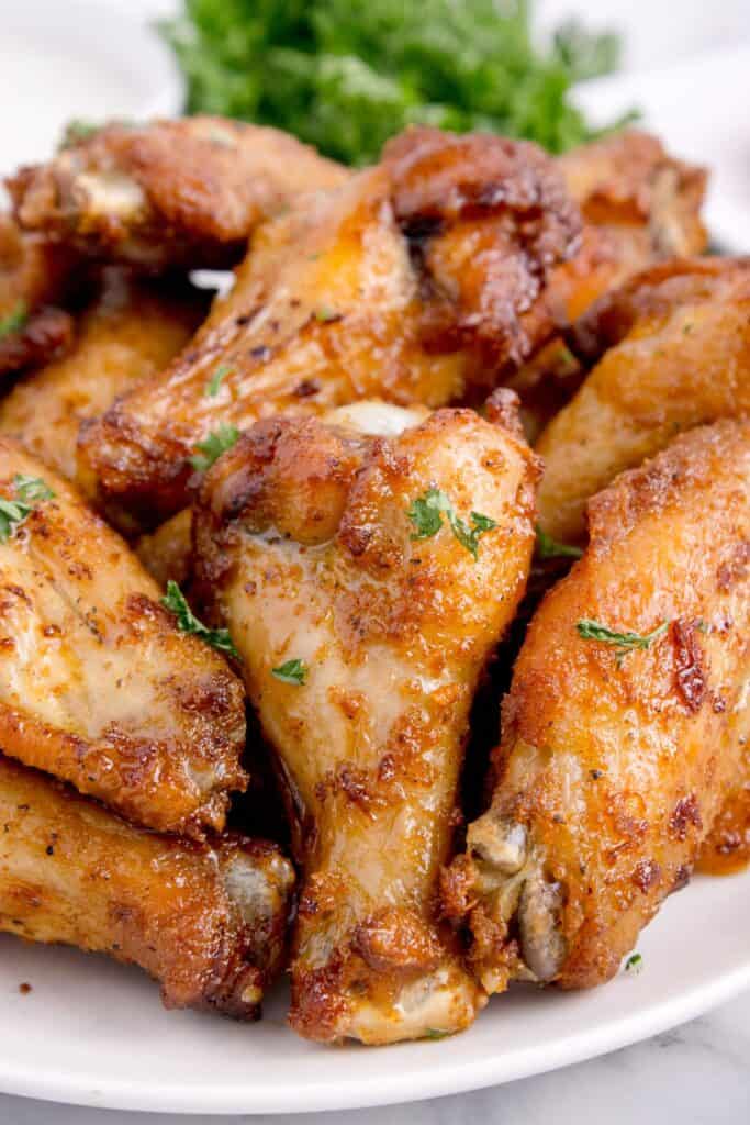 close up of air fryer chicken wings on a white plate.