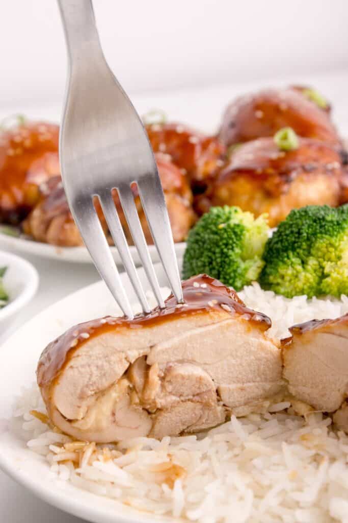 Air fryer chicken thighs cut in half with a fork in it.