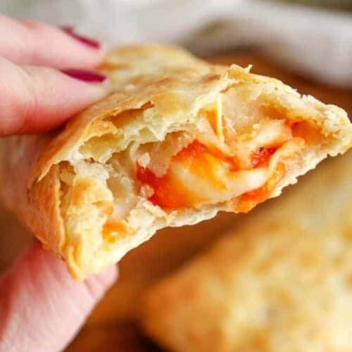 Air Fryer Hot Pocket in hand with cheese oozing out