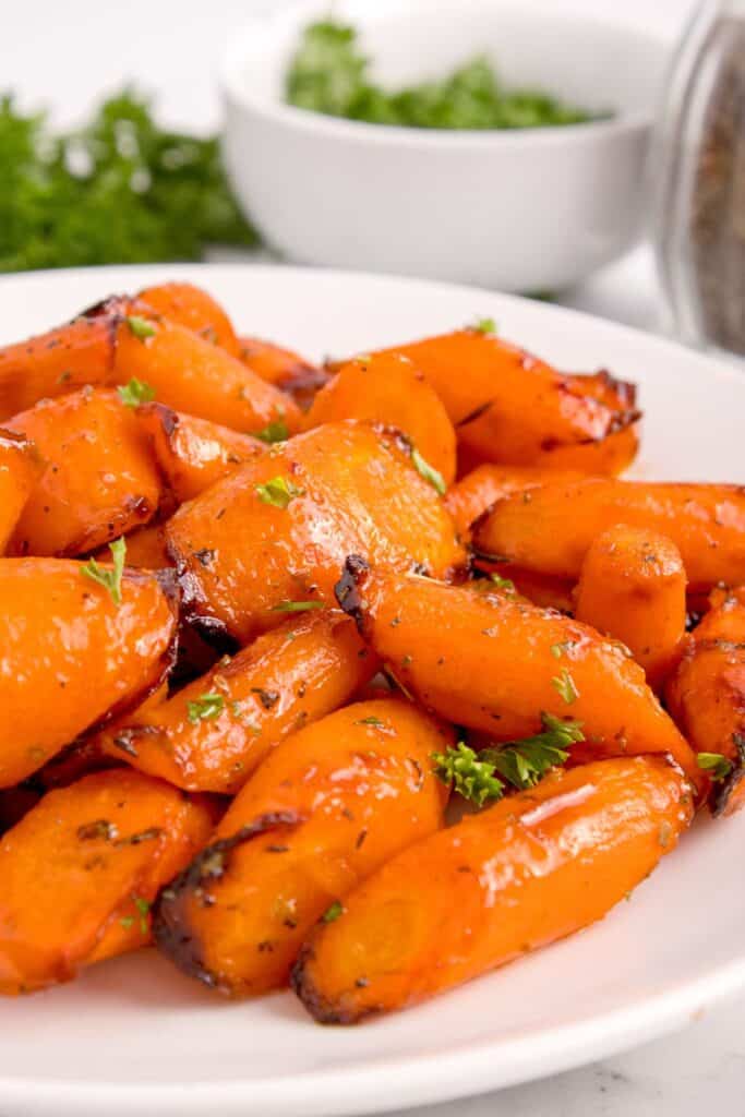 Air fryer carrots cooked and on a white plate from the side.