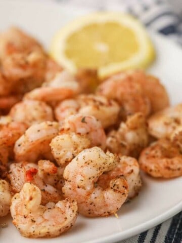 Air Fryer Shrimp on a white plate with lemon slice