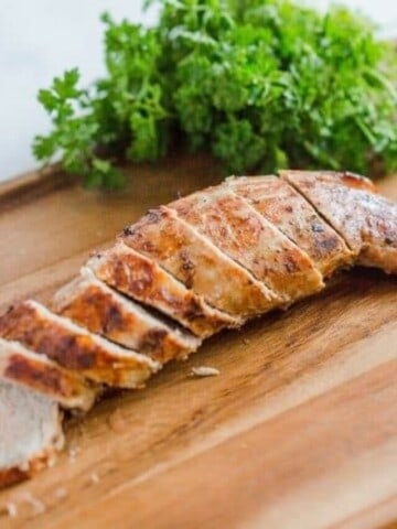 Sliced air fryer pork tenderloin on a cutting board