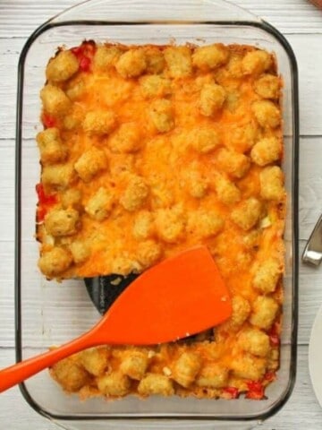 Tater Tot Casserole in 13x9 pan with slices cut out on white plates