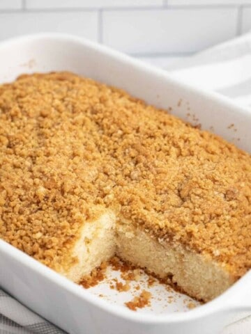 Baked coffee cake in 13x9 white pan with a slice taken out