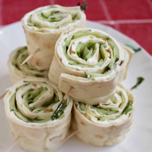 Cucumber and Cream Cheese Rolls served on white plate.