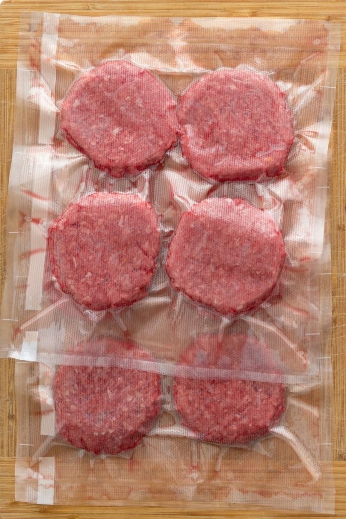 Raw hamburgers vaccuum sealed and ready to be frozen