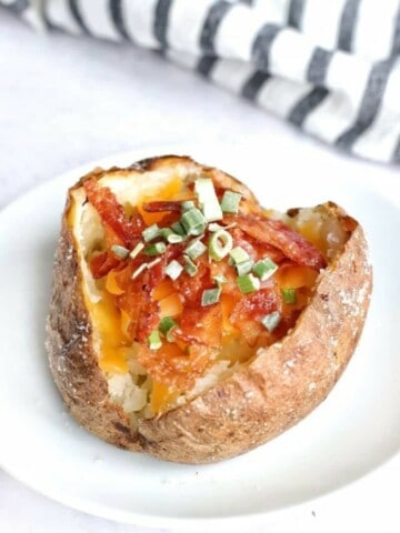 Baked potato topped with bacon, cheese, and chives