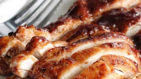 Sliced BBQ chicken thighs that were cooked in the Ninja Foodi on a white plate