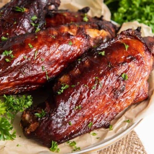 Air Fryer Turkey Wings served on a white plate with parchment paper underneath them