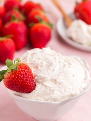strawberry resting in bowl of cool whip fruit dip