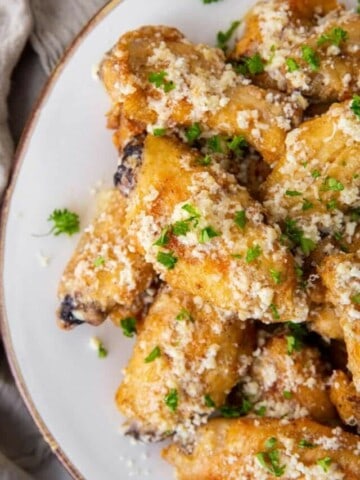 garlic parmesan wings piled on plate