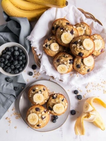 banana blueberry oatmeal muffins on plate with bowl of blueberries on side