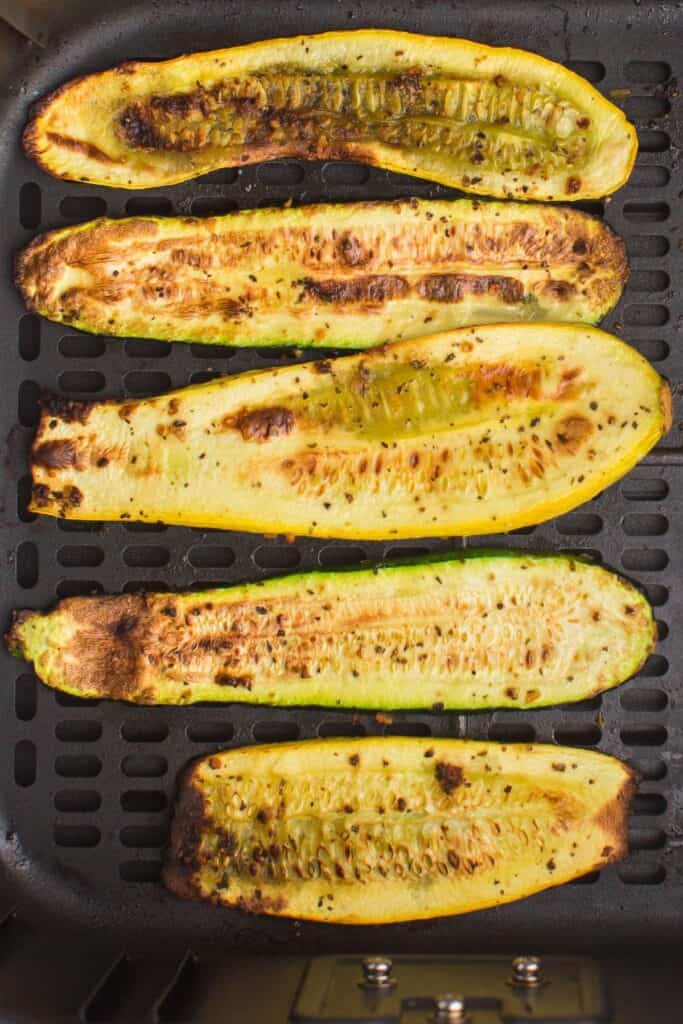 cooked summer squash in an air fryer basket