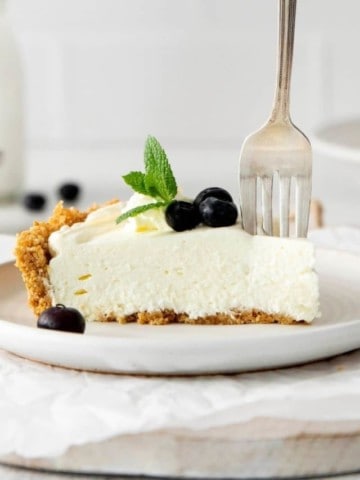 slice of no-bake cheesecake with fork cutting into it