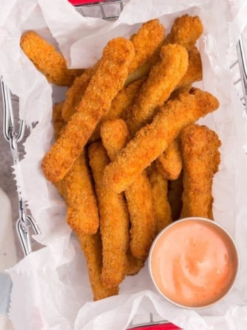 chicken fingers in basket with dipping sauce