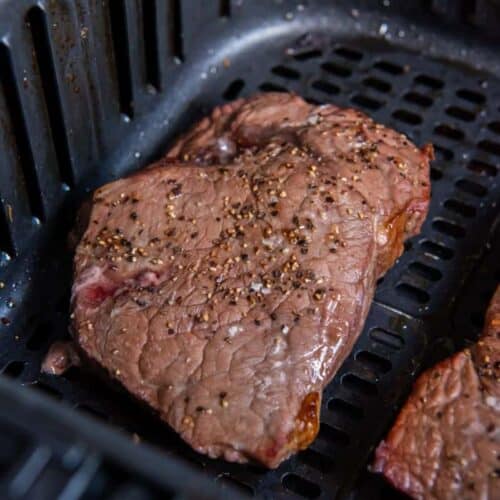 cooked sirloin steak in air fryer basket