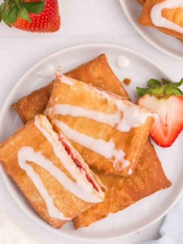 air fryer toaster strudel on white plate with a strawberry