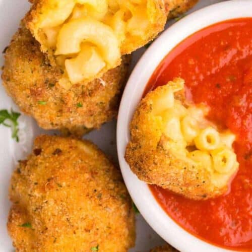 dipping mac and cheese bite into sauce