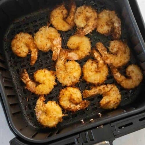 air fryer basket with cooked shrimp