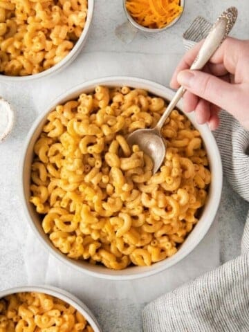 spoon digging into bowl of mac and cheese