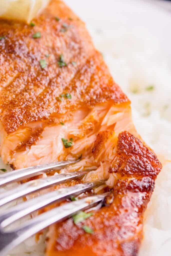 Close up of air fryer salmon being flaked with a fork.