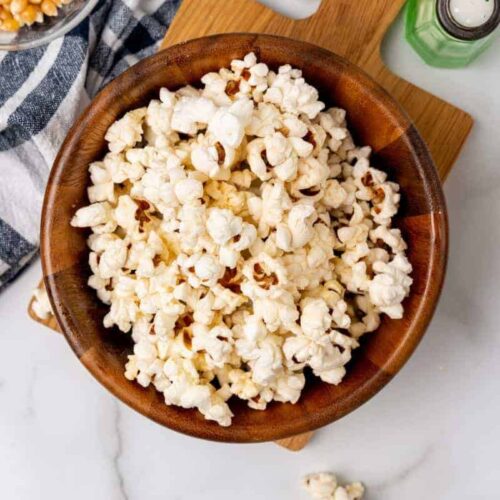 Overhead view of popcorn in a wooden bowl.