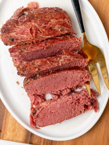 Sliced corned beef on a white plate.