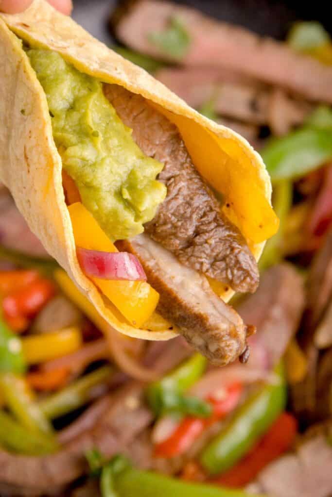 Close up of a steak fajita in a tortilla shell.