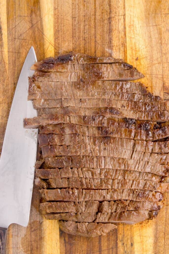 Sliced flank steak cut against the grain to be used for steak fajitas.