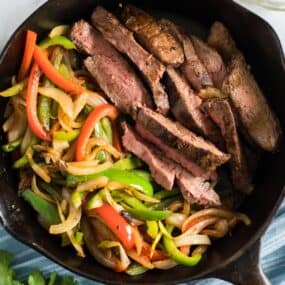 beef steak fajitas in a cast iron skillet.