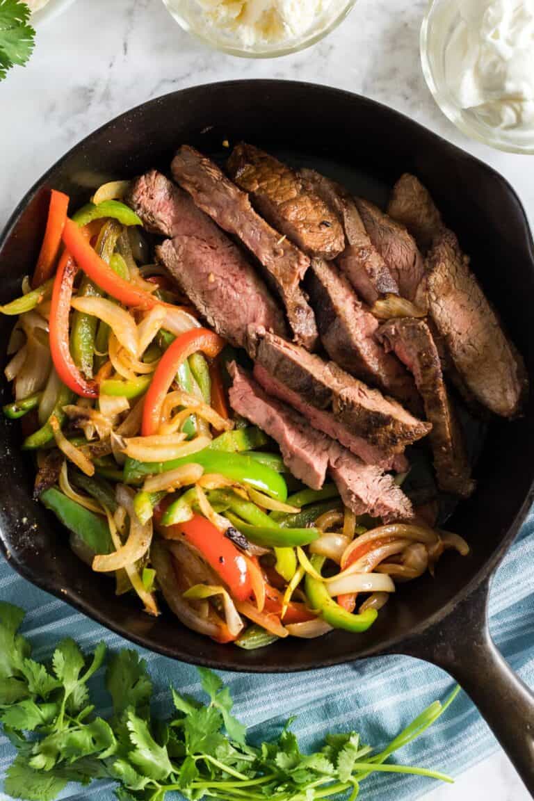 beef steak fajitas in a cast iron skillet.