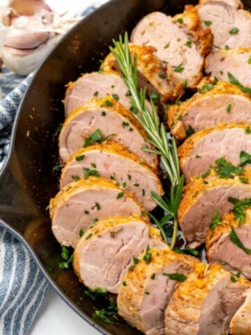 Slices of pork tenderloin prepared in a cast iron skillet.