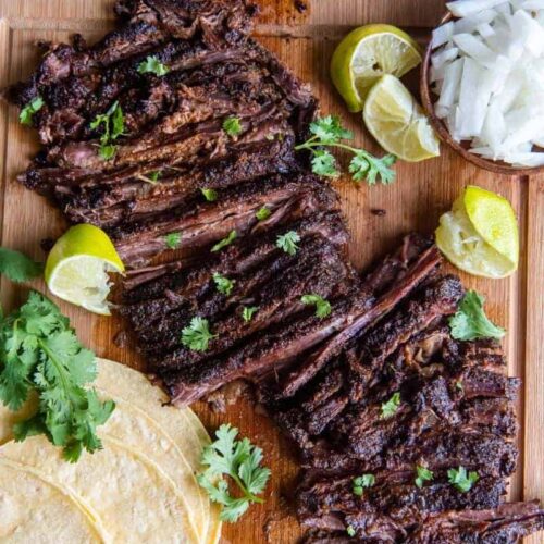 Slices of skirt steak on a wooden cutting board.