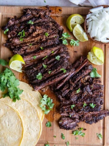 Slices of skirt steak on a wooden cutting board.