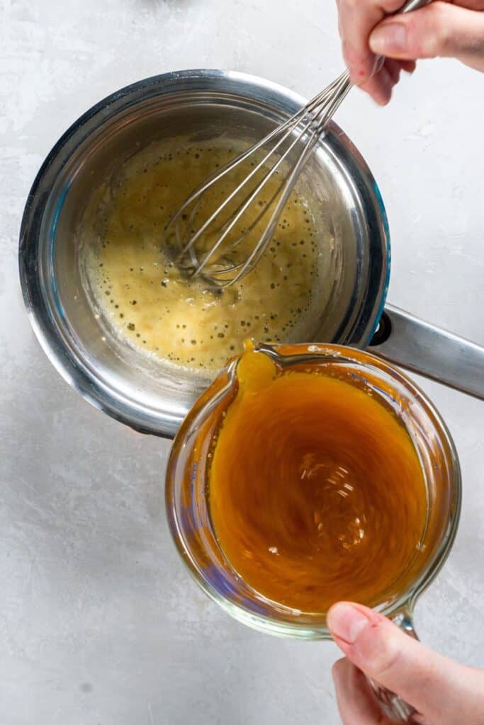 cooking a roux for ham gravy and adding in the ham drippings while whisking.