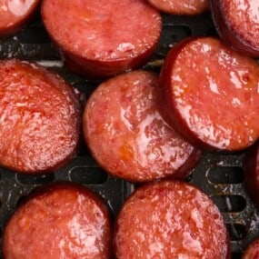 close up air kielbasa in an air fryer basket