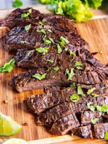 sliced flank steak on a wooden cutting board