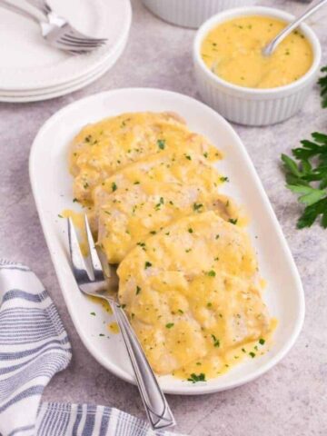 Creamy pork chops served on a small platter.