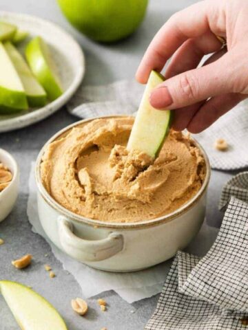 Scooping up some peanut butter yogurt dip on an apple slice.