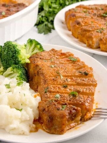 sliced pork chop with mashed potatoes and broccoli