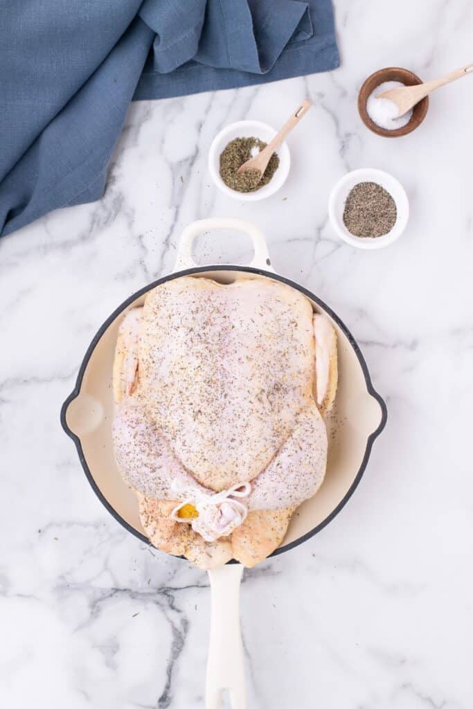 Adding olive oil, salt and pepper to the outer skin of the raw chicken