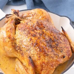 oven roasted chicken in a white cast iron skillet