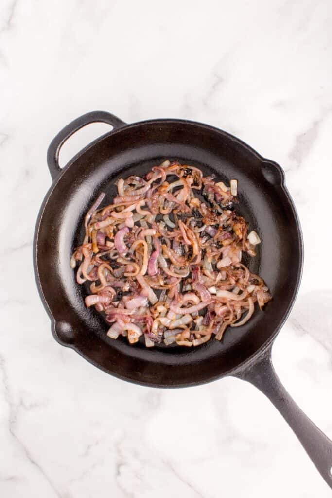 sauteing red onions on a cast iron skillet