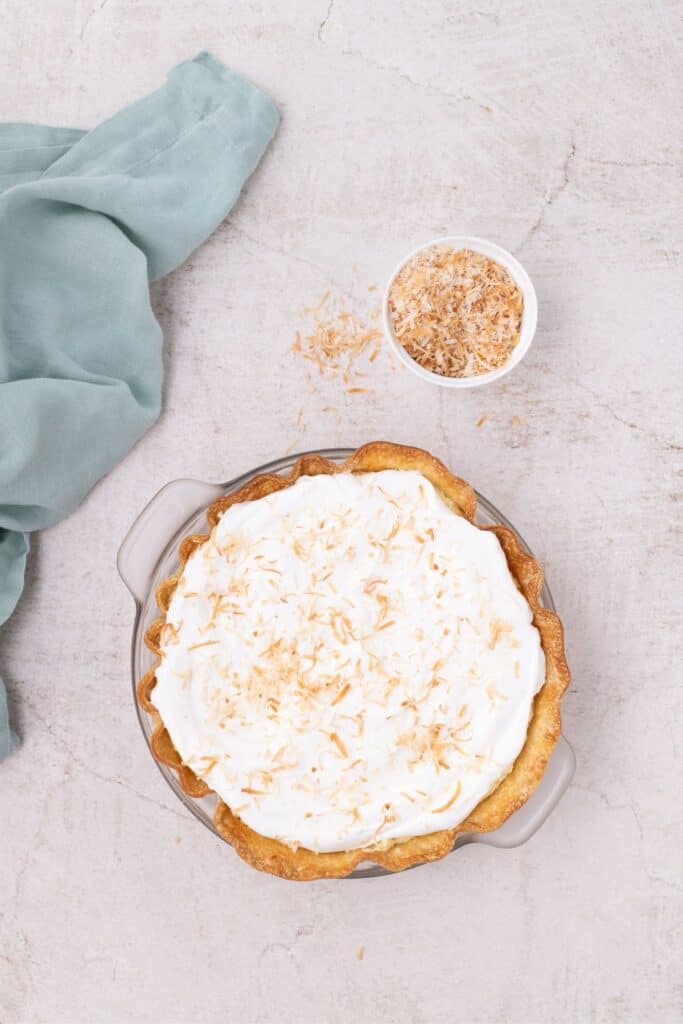 Toasted coconut sprinkled over the top of the assembled Coconut Cream Pie.