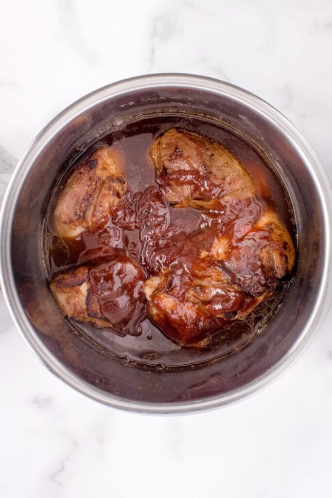 Cooked pork with BBQ sauce in the Instant Pot before it is pressure cooked.