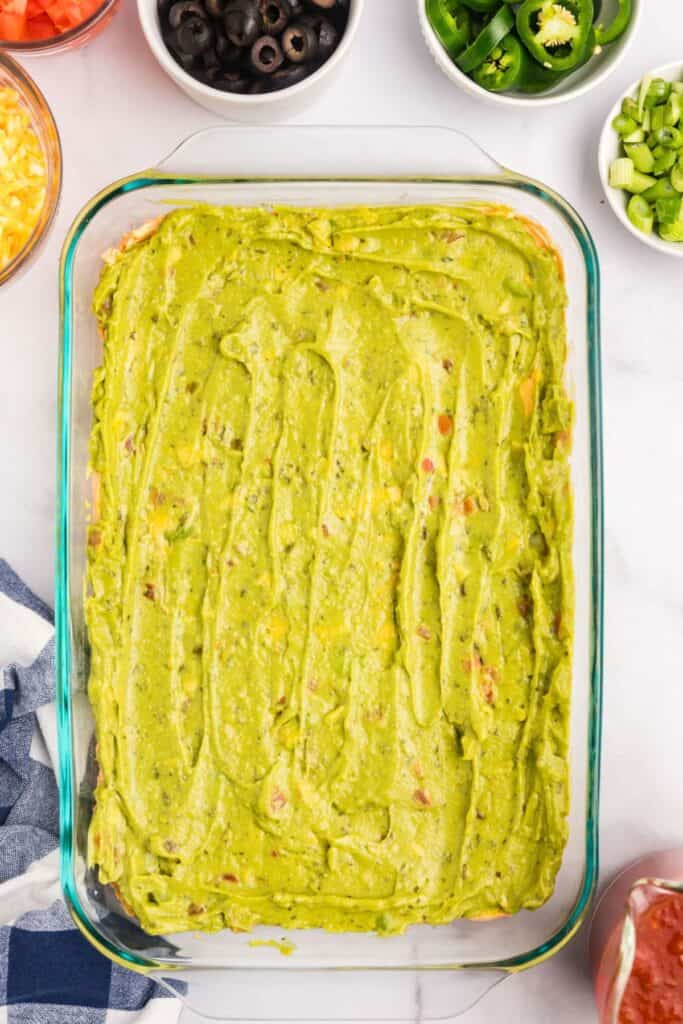 Spread guacamole as the third layer of the 7 layer dip.