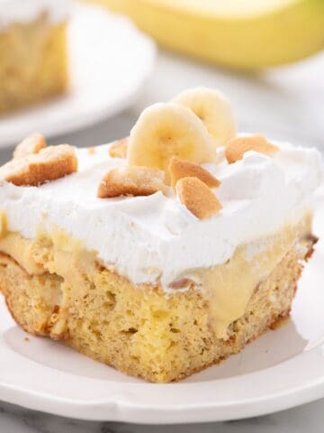 Slice of banana pudding cake on a white plate.