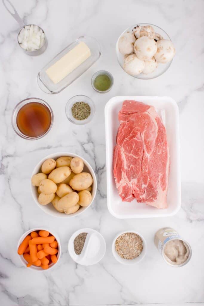 Ingredients for chuck roast recipe. Chuck roast, baby yellow potatoes, baby carrots, onion, Lipton’s beefy onion dry soup mix, mushrooms, olive oil, butter, cream of mushroom soup, Italian seasoning, and beef broth.