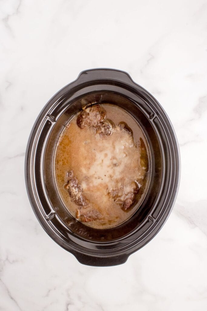 Cooked chuck roast in slow cooker insert.