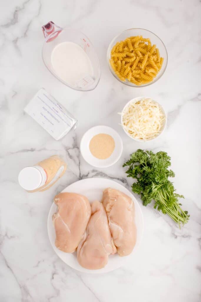 Ingredients needed for Garlic Parmesan Chicken and Pasta. Heavy cream, pasta, parmesan cheese, onion powder, cream cheese, garlic parmesan sauce, chicken breast, parsley.